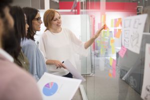 Business people brainstorming in conference room with adhesive n